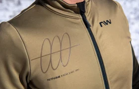Una persona que lleva una chaqueta Northwave de color verde oliva con cremallera negra y un logotipo estampado en el pecho.