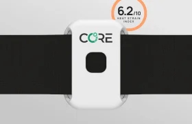 Dispositivo portátil blanco con la etiqueta "CORE" sujeto a una correa negra, con un círculo naranja que muestra "6.2/10 Heat Strain Index" en la esquina superior derecha.