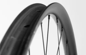 Primer plano de dos llantas de bicicleta con radios, una en primer plano y otra ligeramente más atrás, sobre un fondo blanco liso.
