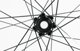 Primer plano del buje y los radios de una rueda de bicicleta, vistos desde el centro, sobre un fondo blanco.