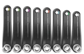 Ocho bielas SRAM negras están alineadas una al lado de la otra, cada una con un círculo de color cerca del orificio del pedal e idénticas marcas de las Novedades SRAM febrero 2026.