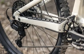 Primer plano del cambio trasero, el cassette, la cadena y la vaina trasera de una bicicleta eléctrica de montaña (e-MTB) de la marca FOCUS, en el que se aprecian los cambios de la bicicleta y parte de la rueda trasera.
