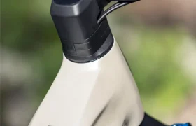 Primer plano del cuadro y el manillar de una bicicleta de color beige, con la inscripción «JAM» escrita verticalmente en el lateral, que pone de relieve el diseño elegante característico de los modelos de e-MTB de FOCUS.