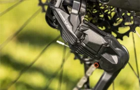 Primer plano del cambio trasero y el cassette de una bicicleta eléctrica de montaña FOCUS e-MTB 2027, con la bicicleta sobre la hierba y los componentes perfectamente enfocados.
