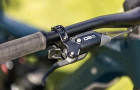 Primer plano del manillar de una bicicleta en el que se aprecian un puño, una palanca de freno y un componente con la inscripción «DB8», con un fondo exterior difuminado, tal y como se ve en el modelo FOCUS e-MTB 2027 SAM.
