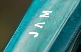 Primer plano de una superficie de color turquesa con la palabra «JAM» impresa en mayúsculas blancas, vista desde un ángulo: un detalle que da una idea de la atrevida línea de diseño de la bicicleta eléctrica de montaña Gama FOCUS e-MTB 2027.