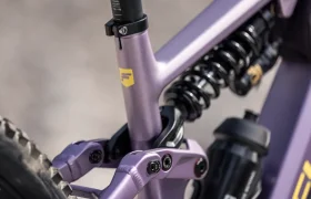 Primer plano de un cuadro de bicicleta de montaña de color morado, en el que se aprecian el muelle de la suspensión trasera, el tubo del sillín y parte de la rueda trasera, lo que pone de relieve los innovadores elementos de diseño inspirados en los próximos modelos de e-MTB de 2027, como la JAM y la SAM.