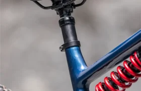 Primer plano del sillín, la tija telescópica, el muelle de suspensión y parte de la rueda trasera de una bicicleta eléctrica de montaña Gama FOCUS e-MTB 2027 azul.