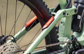 Primer plano de la rueda trasera y el sistema de cambios de una bicicleta de montaña FOCUS e-MTB 2027 de color verde claro con la marca «THRON», fotografiada al aire libre.