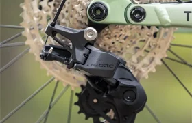 Primer plano del desviador trasero, el cassette y la cadena de una bicicleta, con un fondo exterior desenfocado. El desviador lleva la inscripción «Deore», y la configuración sugiere la sólida ingeniería que se aprecia en modelos como la FOCUS e-MTB 2027 JAM.