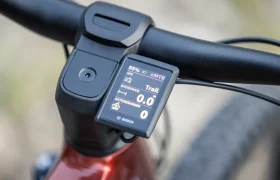Primer plano del manillar de una bicicleta eléctrica de montaña Gama FOCUS 2027 con una pantalla Bosch que muestra el nivel de batería, la velocidad, el modo y otra información de conducción: perfecta para tu próxima aventura JAM o SAM.
