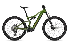 Bicicleta de montaña eléctrica (e-MTB) Green de 2027 con suspensión total, neumáticos anchos, frenos de disco y motor de tracción central, mostrada en una vista lateral sobre un fondo blanco.