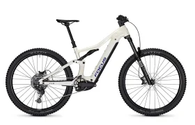 Bicicleta eléctrica de montaña «FOCUS e-MTB 2027 JAM» de color blanco, con suspensión delantera, frenos de disco y neumáticos Maxxis de gran grosor, mostrada de perfil sobre un fondo liso.
