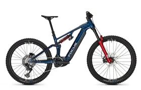 Bicicleta de montaña Blue Focus JAM con suspensión total, horquilla delantera roja, neumáticos grandes con tacos y un amortiguador trasero de muelle visible, mostrada de perfil sobre un fondo blanco.