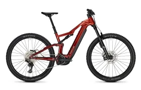 La FOCUS e-MTB 2027 JAM es una bicicleta de montaña eléctrica de doble suspensión de color rojo, equipada con potentes frenos de disco, neumáticos anchos y una batería integrada, que se muestra en vista de perfil sobre un fondo blanco.
