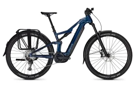 Bicicleta eléctrica de montaña azul, la JAM e-MTB 2027, con suspensión delantera, portaequipajes trasero, guardabarros delanteros y traseros, frenos de disco y neumáticos con dibujo pronunciado, mostrada de perfil sobre un fondo blanco.