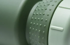 Primer plano de una tapa de botella de agua verde y con textura, con un agarre de goma y bordes estriados, en un bidón mate a juego que cuenta con protección antimicrobiana y el avanzado sistema Fabric Gripper V2 para un agarre seguro.