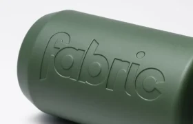 El bidón antimicrobiano Fabric Gripper V2, un objeto cilíndrico de color verde con la palabra «fabric» grabada en relieve en su superficie, ofrece protección permanente y aparece fotografiado sobre un fondo blanco liso.
