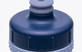 Primer plano de una botella deportiva azul y gris con un agarre texturizado y una boquilla de tipo «push-pull». La palabra «Fabric» aparece grabada en relieve en la tapa, lo que pone de relieve el avanzado diseño Fabric Gripper V2 para un manejo cómodo. Esta botella antimicrobiana también ofrece protección permanente para ayudarte a mantener tu hidratación limpia y segura.