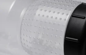 Primer plano de un bidón de plástico transparente con un agarre texturizado y punteado que incorpora la tecnología Fabric Gripper V2 y un tapón roscado negro, fotografiado sobre un fondo neutro. La botella está diseñada para ofrecer una mayor protección antimicrobiana y garantizar así una hidratación segura e higiénica.