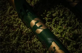 Primer plano de un cuadro de bicicleta FOX 38 Racing Green con letras "FOX" doradas, tendido sobre musgo verde vibrante.