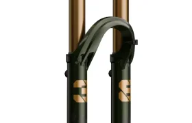 Una horquilla de suspensión FOX Factory para bicicleta de montaña con montantes dorados y bajos FOX 38 Racing Green, vista de frente sobre fondo blanco.
