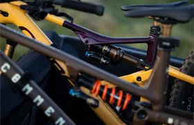 Dos bicicletas de montaña de suspensión total con amortiguadores traseros FOX y amortiguadores visibles se aseguran en la parte trasera de un vehículo.