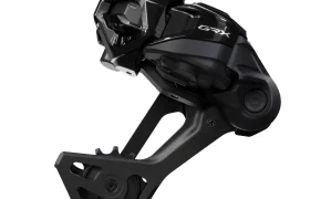 Primer plano de un cambio trasero Shimano GRX negro para bicicletas, que muestra sus ruedas de polea y su elegante diseño mecánico.