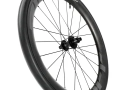 Una rueda de bicicleta de carbono Zipp 808 Firecrest con radios negros y calcomanías blancas, mostrada en ángulo sobre un fondo blanco, diseñada para rodar más rápido y lista para la innovación de Zipp 2026.