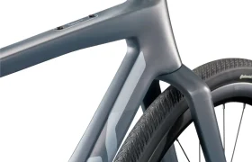 Primer plano de una BMC Kaius 01, una bicicleta rápida con cuadro y cubierta trasera modernos, en la que destacan los tubos lisos y angulosos y la banda de rodadura detallada de la bicicleta moderna.