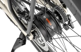 Primer plano de la rueda trasera de la bicicleta Moustache Lundi 27, equipada con un motor eléctrico Bosch integrado en el buje, un sistema de frenos de disco y radios: perfecta para desplazarse sin esfuerzo por la ciudad.