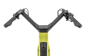 Vista de cerca del manillar y el panel de control de una bicicleta eléctrica amarilla «Moustache Lundi 27», en la que se aprecian los puños de control, las palancas de freno y la pantalla central desde una perspectiva frontal superior, ideal para moverse por la ciudad con estilo y comodidad.