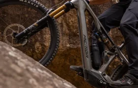 Un ciclista, que lleva casco y gafas de sol, sube en una bicicleta de montaña Merida por una empinada pendiente rocosa.