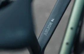 Primer plano de un cuadro de bicicleta MMR Aelion SL rotulado "AEROLOW SL" cerca de la tija del sillín, con parte del sillín y la cubierta visibles: una auténtica bici total.