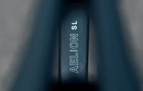 Primer plano de un sillín de bicicleta MMR Aelion SL con el texto "AELON SL ROAD" impreso en su superficie, parcialmente enmarcado por bordes difuminados: un verdadero detalle bici total.