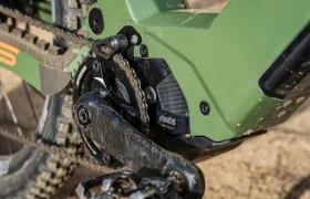 Primer plano del motor y el mecanismo de cadena de una bicicleta eléctrica verde en un camino de tierra, mostrando la potencia italiana de la Polini E-P3+ MX.