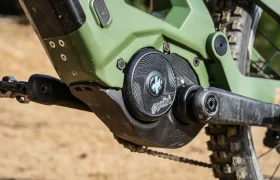 Primer plano del motor y el sistema de manivela Polini E-P3+ de una bicicleta de montaña eléctrica ecológica, que muestra componentes cubiertos de tierra y un neumático resistente, resaltando su potencia italiana en un entorno al aire libre.