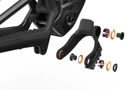 Vista despiezada de la bieleta de suspensión de una bicicleta UNNO MITH. Se muestran diversos componentes, como bujes y soportes, separados del cuadro principal, destacando los detalles del ensamblaje.
