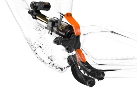 Primer plano de un cuadro de bicicleta UNNO MITH transparente que muestra componentes de suspensión detallados con un detalle naranja y un amortiguador negro, resaltando el diseño de ingeniería y la funcionalidad.
