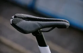 Primer plano de un sillín de bicicleta PRO Stealth 3D, negro y con diseño de panal, montado sobre una tija de sillín, con un fondo exterior difuminado.