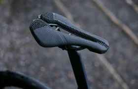 Primer plano de un moderno sillín de bicicleta PRO Stealth 3D de color negro con diseño de panal de abeja, montado en una tija de bicicleta.