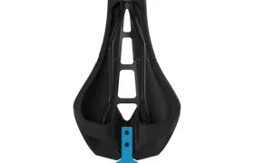 Sillín de bicicleta ergonómico PRO Stealth 3D negro con un recorte central y una etiqueta circular azul pegada en la parte inferior, visto desde arriba sobre fondo blanco.