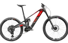 La Rotwild R.EXC es una bicicleta de montaña eléctrica con suspensión total, cuadro negro y rojo, neumáticos de tacos anchos, amortiguadores delantero y trasero y un motor de tracción central diseñado para competir en los senderos más difíciles.