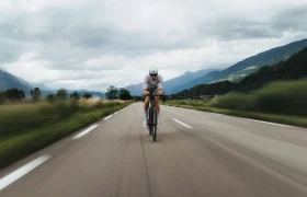 Un ciclista circula con una LOOK 795 Blade RS 3 por una carretera cerca de Nevers, con las montañas al fondo.