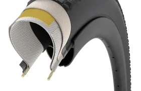 Sección transversal de un neumático de bicicleta Pirelli Cinturato Gravel que muestra múltiples capas internas, bandas de rodadura en la superficie exterior y dos hilos de talón en la base: una opción avanzada para los entusiastas de los neumáticos de grava.
