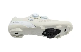 Unas zapatillas de ciclismo blancas Shimano RX710 con doble cierre de dial y una cala integrada en la suela, que incorporan tecnología de competición ideal para salidas de gravel, mostradas sobre un fondo blanco liso.