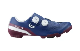 Unas zapatillas de ciclismo en azul y granate con detalles en blanco, dos cierres de rueda y el modelo «RX7» impreso en el lateral; las zapatillas Shimano RX710 combinan tecnología de competición ideal para el gravel.