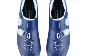 Un par de zapatillas de ciclismo Shimano RX710 azules con cierres de dial blancos y plantillas negras, diseñadas con tecnología de competición para el ciclismo de grava, vistas desde arriba sobre un fondo blanco.