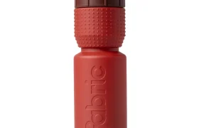 Botella de agua de plástico roja con un tapón de rosca marrón texturizado y la palabra «fabric» grabada en relieve verticalmente en el lateral, representada sobre un fondo blanco. Este bidón antimicrobiano Fabric Gripper V2 ofrece protección permanente para tus necesidades de hidratación.