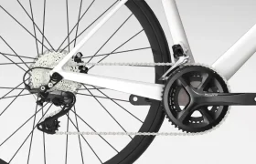 Primer plano de una transmisión de bicicleta con el cambio trasero Shimano Tiagra R4000, el casete, la cadena y las bielas sobre un fondo blanco.